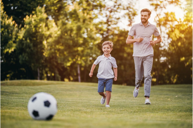 Jongen speelt voetbal met papa