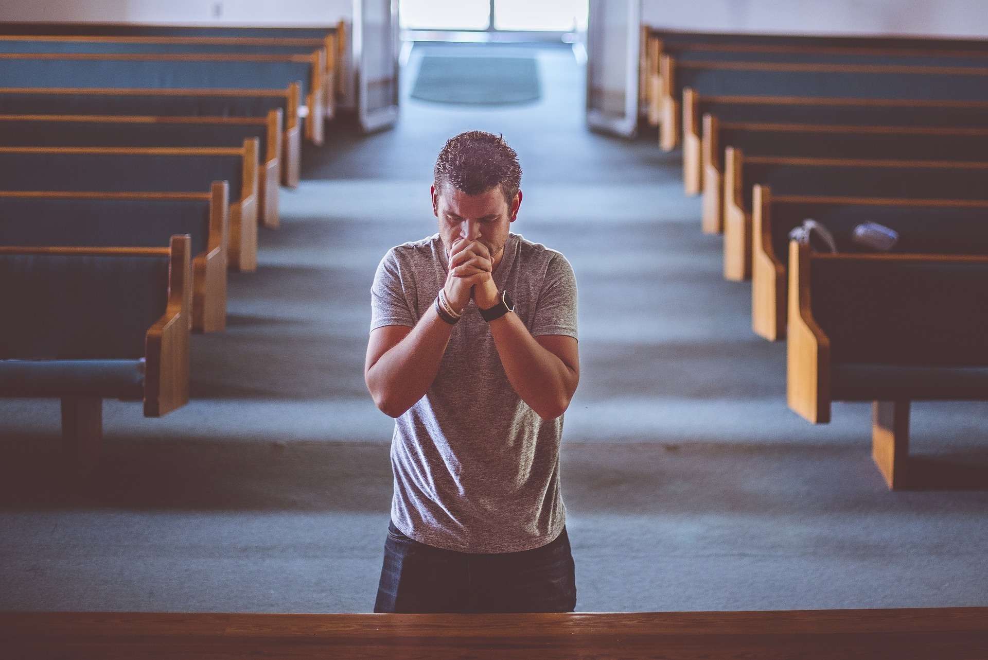 Man praying in a church on his knees