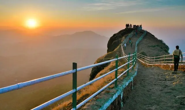 Panoramic view of Sunset Point in Mahabaleshwar with vibrant sunset colors over the hills